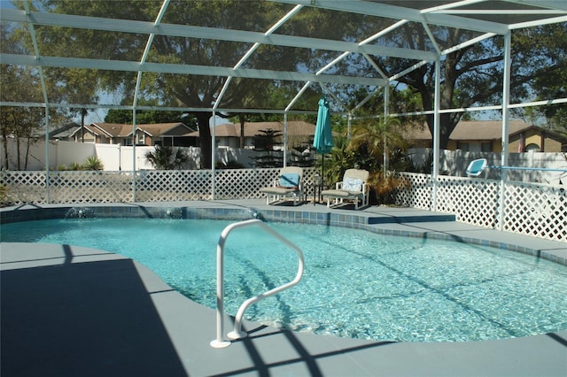 view of swimming pool with a lanai, a patio area, fence, and a fenced in pool