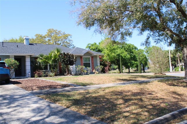 view of front of home featuring a front lawn and roof with shingles