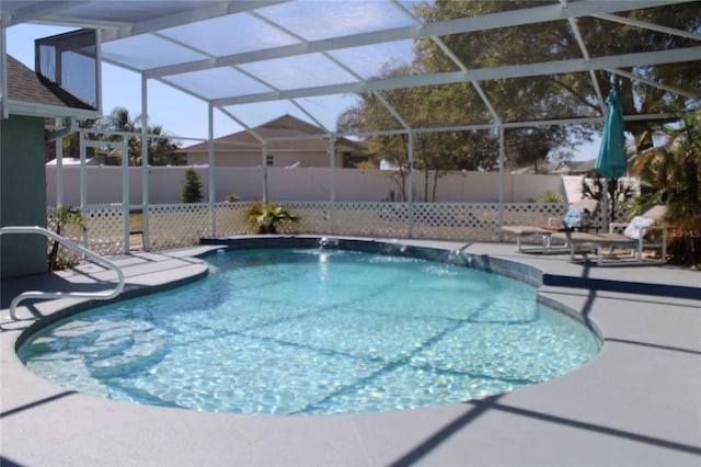 view of swimming pool with glass enclosure, a fenced backyard, a fenced in pool, and a patio