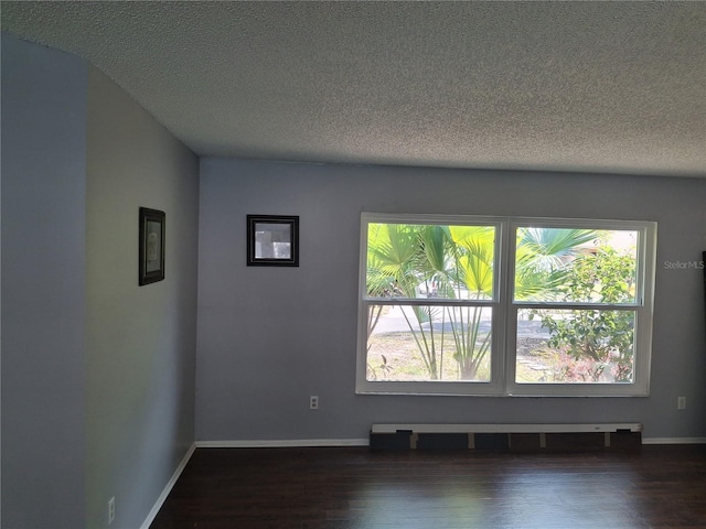 unfurnished room featuring plenty of natural light, a textured ceiling, and wood finished floors