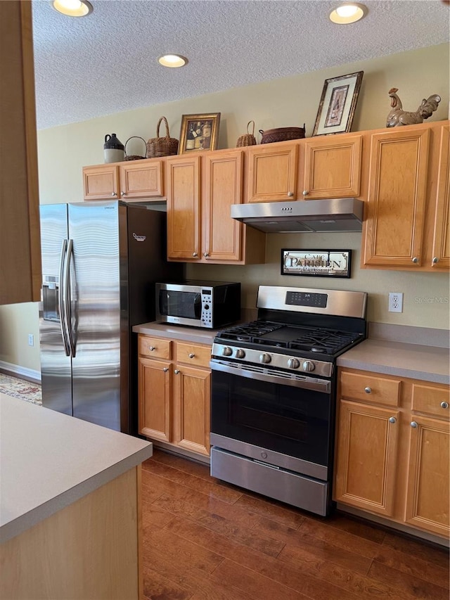 kitchen with stainless steel appliances, dark wood-style flooring, under cabinet range hood, and a textured ceiling