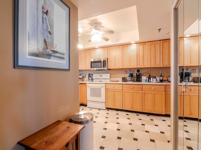 kitchen featuring light brown cabinets, ceiling fan, light countertops, stainless steel microwave, and white range with electric stovetop