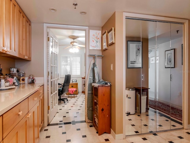 kitchen with gas water heater, light brown cabinets, a ceiling fan, and light countertops