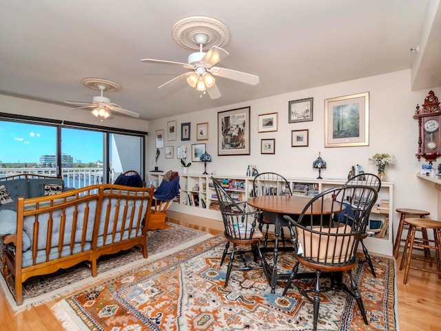 dining room featuring baseboards, a ceiling fan, and wood finished floors