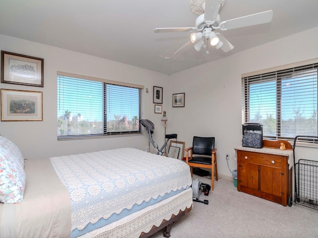 bedroom with multiple windows, light colored carpet, and ceiling fan