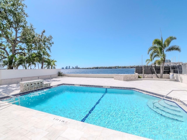 community pool with a patio area and fence