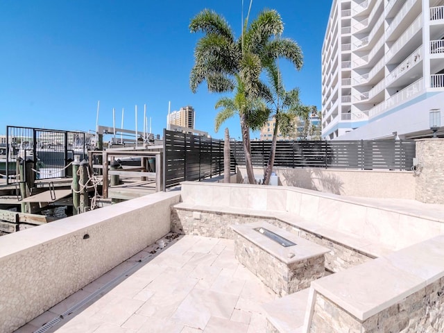 view of patio with a boat dock, a fire pit, and boat lift