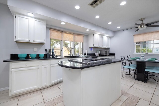 kitchen with dark countertops, black electric stovetop, recessed lighting, and white cabinets