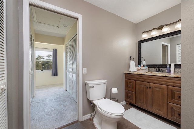 bathroom with toilet, vanity, and baseboards