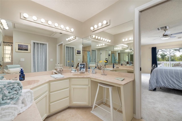 full bath featuring visible vents, ceiling fan, a sink, a textured ceiling, and connected bathroom