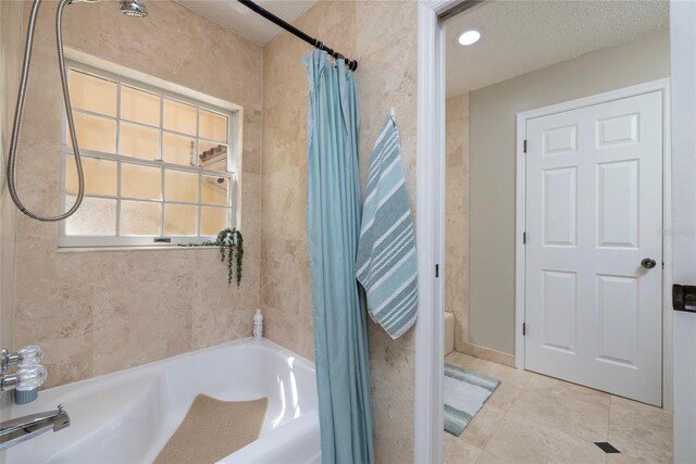 full bathroom with a bathtub, tile patterned flooring, a textured ceiling, and a shower with shower curtain