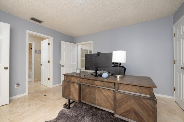 office area featuring visible vents, baseboards, and a textured ceiling