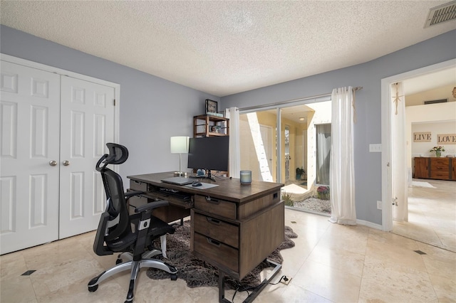 office space featuring light tile patterned floors, visible vents, and a textured ceiling