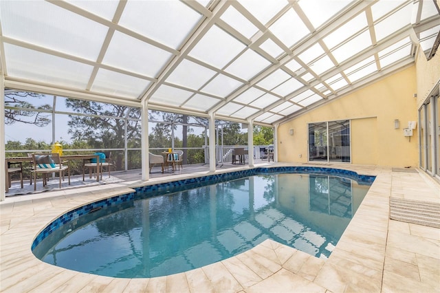 indoor pool with a lanai, outdoor dining space, and a patio