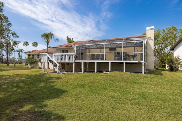 rear view of house with a lanai, a lawn, and a chimney