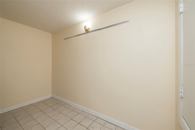 spare room with baseboards and a textured ceiling