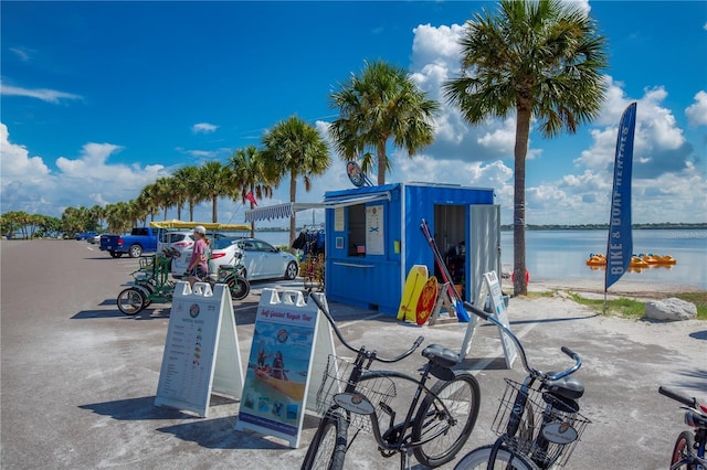 view of home's community with a water view and uncovered parking