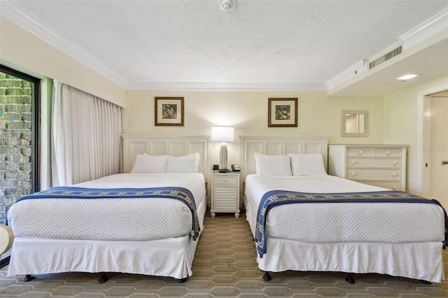 bedroom featuring ornamental molding, visible vents, and a textured ceiling