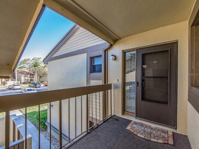 entrance to property with a balcony and stucco siding