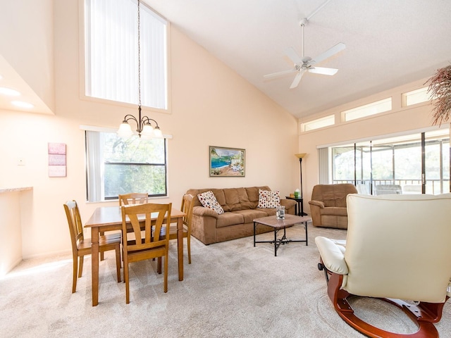 living room with ceiling fan with notable chandelier, light colored carpet, and high vaulted ceiling