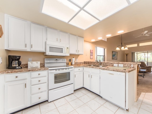 kitchen with ceiling fan with notable chandelier, a peninsula, white cabinets, white appliances, and a sink