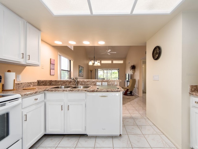 kitchen featuring white cabinets, white appliances, a peninsula, and a sink