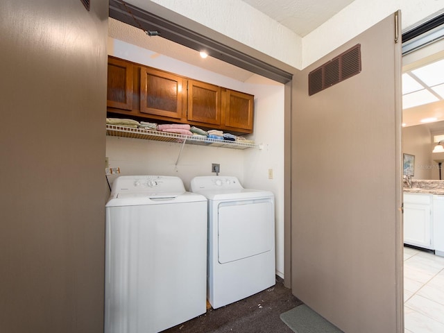 laundry room with visible vents, cabinet space, and separate washer and dryer