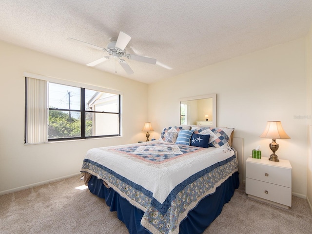 bedroom with a ceiling fan, baseboards, carpet floors, and a textured ceiling