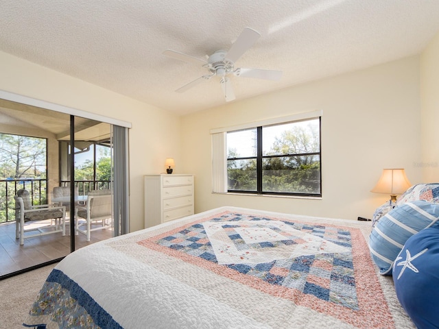 bedroom featuring access to exterior, a textured ceiling, and a ceiling fan