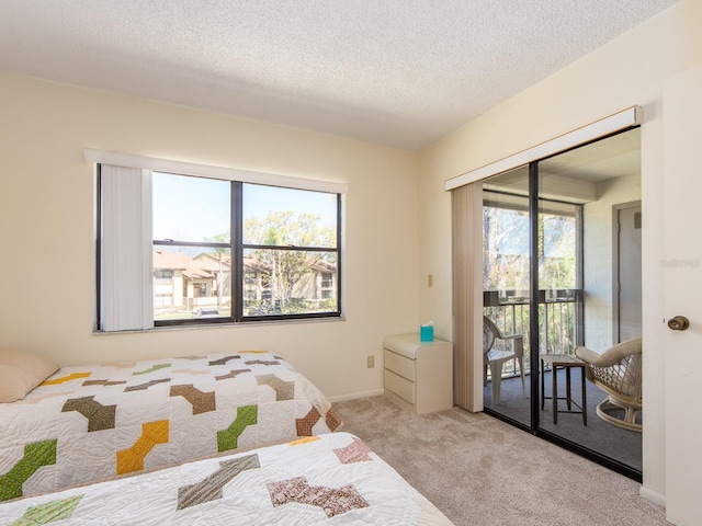 bedroom featuring access to outside, baseboards, carpet floors, and a textured ceiling