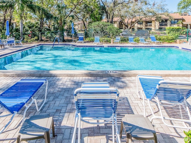 pool featuring fence and a patio area