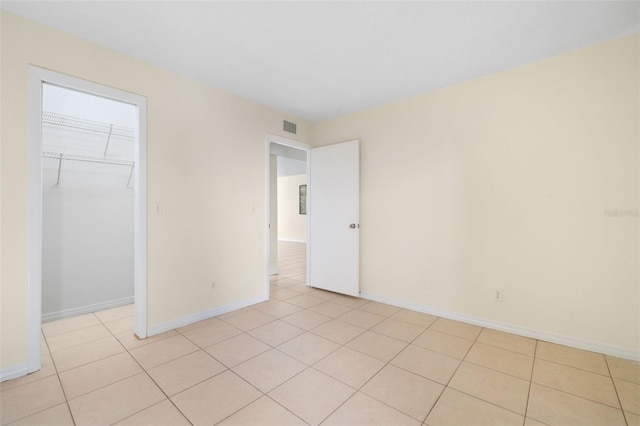 unfurnished room with visible vents, baseboards, and light tile patterned floors