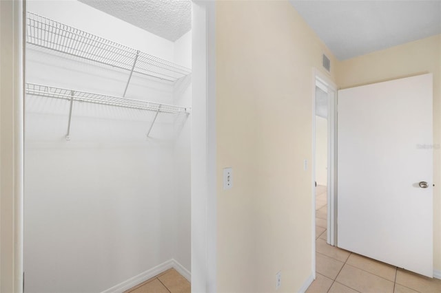 interior space with attic access, visible vents, and light tile patterned floors