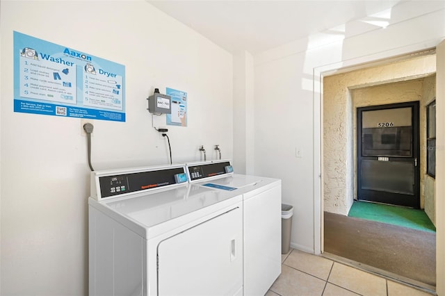 shared laundry area with separate washer and dryer and light tile patterned floors