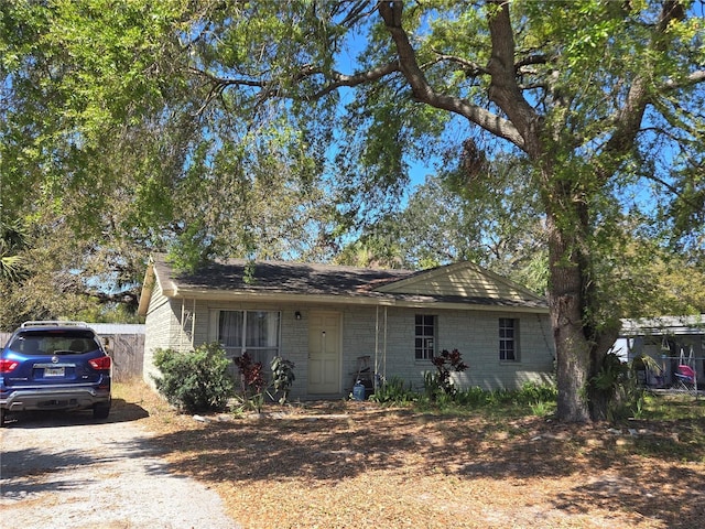 ranch-style house featuring driveway and concrete block siding