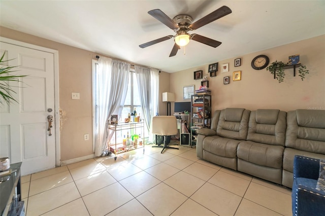 living room featuring light tile patterned floors, ceiling fan, and baseboards