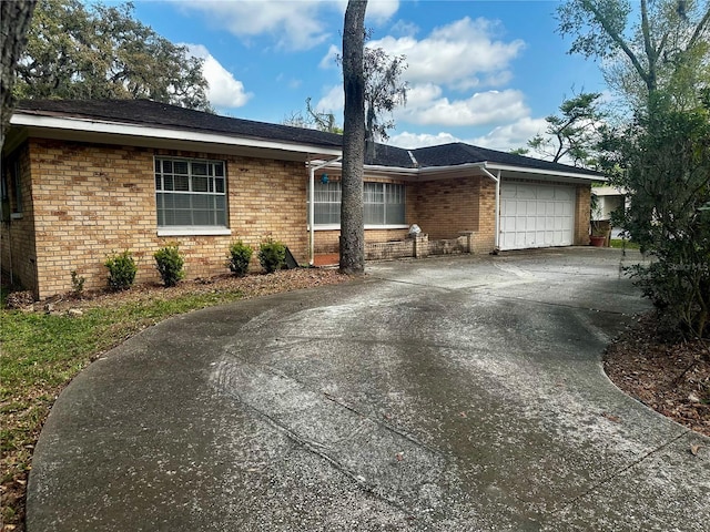 ranch-style house with a garage, brick siding, and driveway