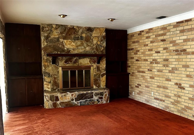 unfurnished living room with carpet, visible vents, a fireplace, and brick wall