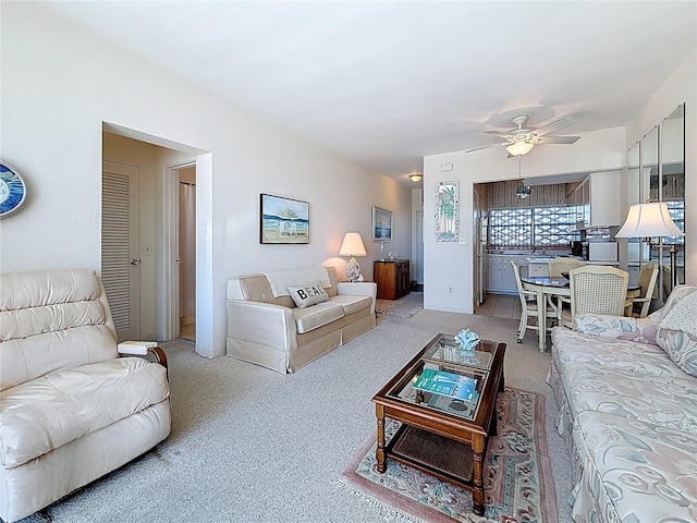 living area featuring a ceiling fan and carpet floors