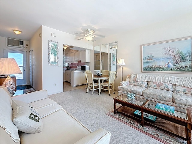 living area featuring light carpet and a ceiling fan