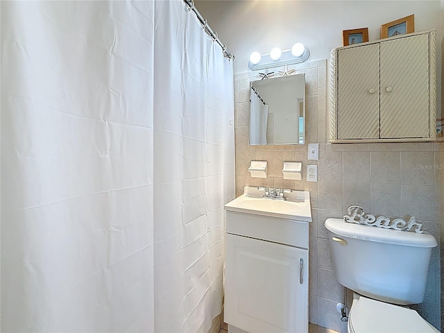 bathroom featuring tile walls, toilet, and vanity