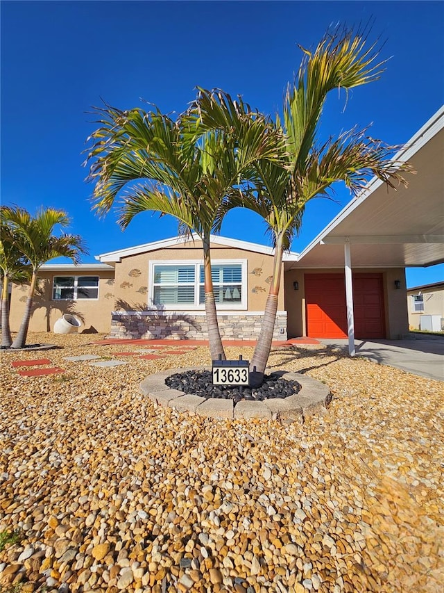 13633 Britton Dr, Hudson, FL 34667 - ranch-style home featuring concrete driveway, a garage, and stucco siding