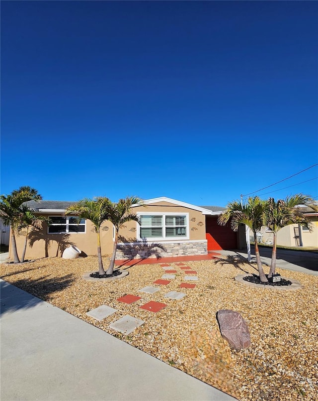 13633 Britton Dr, Hudson, FL 34667 - ranch-style home featuring an attached garage, stone siding, driveway, and stucco siding