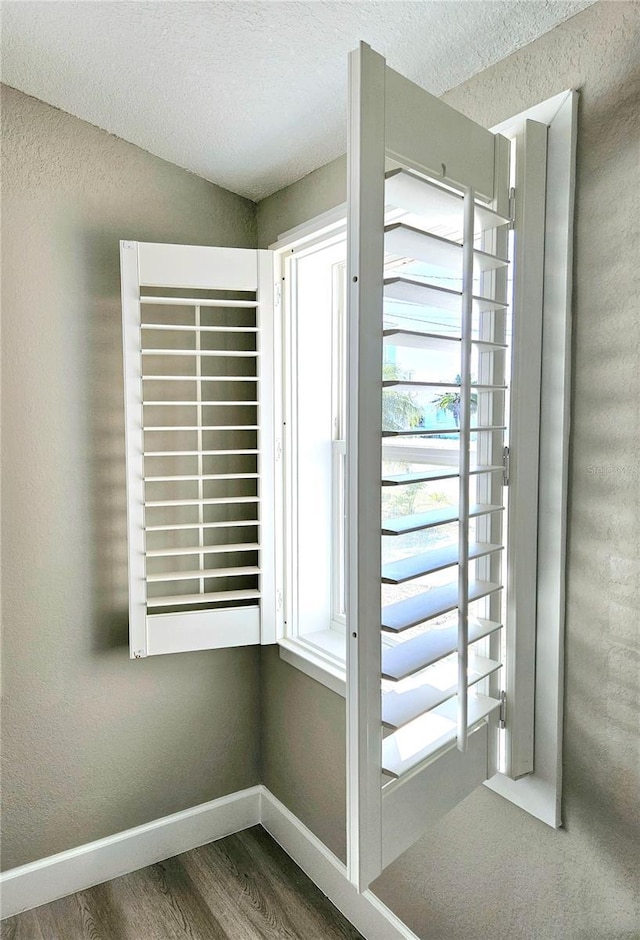 13633 Britton Dr, Hudson, FL 34667 - doorway featuring baseboards, a textured ceiling, and wood finished floors