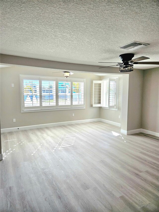 13633 Britton Dr, Hudson, FL 34667 - unfurnished living room featuring visible vents, baseboards, light wood-type flooring, and a ceiling fan