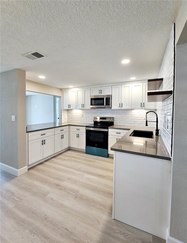 13633 Britton Dr, Hudson, FL 34667 - kitchen with tasteful backsplash, open shelves, a sink, appliances with stainless steel finishes, and light wood finished floors