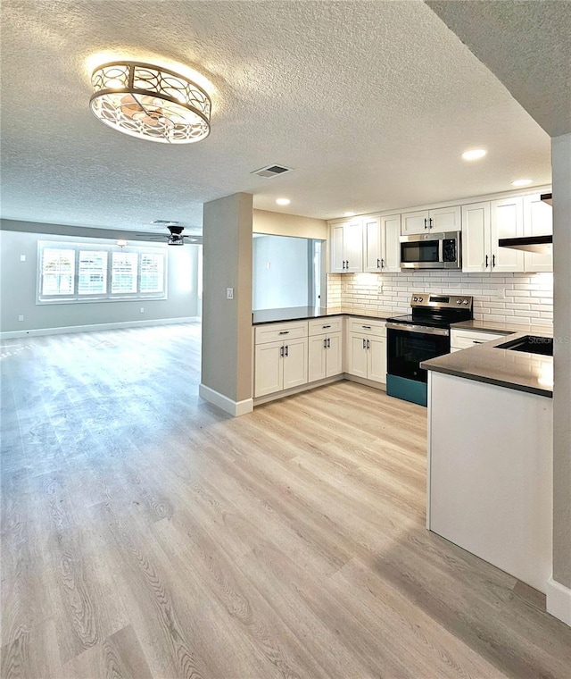 13633 Britton Dr, Hudson, FL 34667 - kitchen featuring tasteful backsplash, light wood-type flooring, appliances with stainless steel finishes, and visible vents