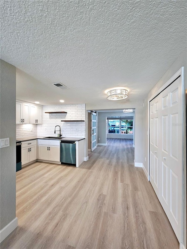 13633 Britton Dr, Hudson, FL 34667 - kitchen featuring tasteful backsplash, white cabinets, visible vents, stainless steel dishwasher, and light wood finished floors