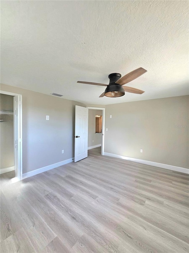 13633 Britton Dr, Hudson, FL 34667 - unfurnished bedroom featuring visible vents, baseboards, ceiling fan, light wood-type flooring, and a textured ceiling