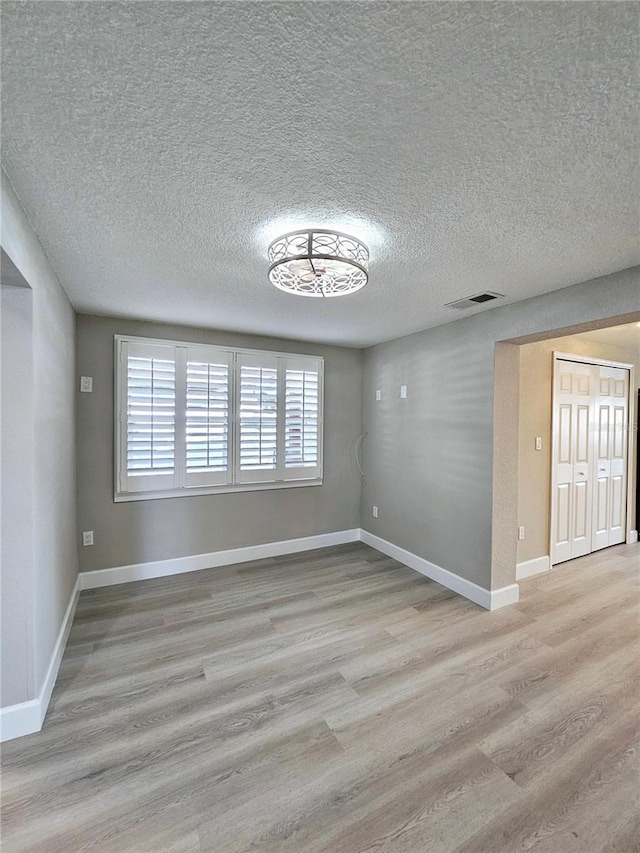 13633 Britton Dr, Hudson, FL 34667 - empty room featuring visible vents, baseboards, a textured ceiling, and wood finished floors